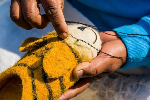 Hands of a woman working on felt shoes