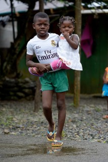 Boy carrying his little sister in his arms
