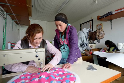 Girl and teacher using sewing machine