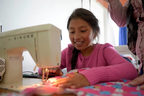 Girl using sewing machine