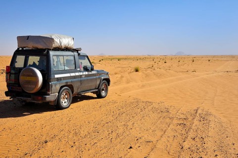 All-terrain vehicle with a roof tent on the dirt track