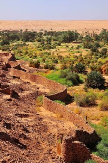 Ruins of the fortified trading post or Ksar with ramparts and oasis