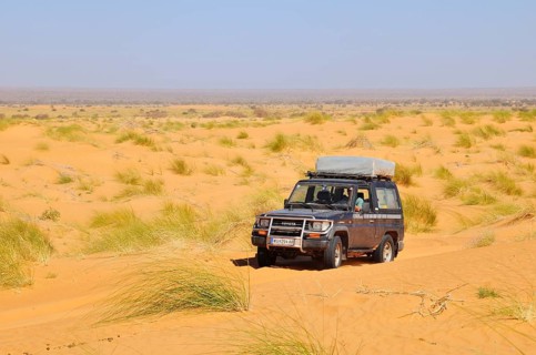 SUV with roof tent on the road in the desert