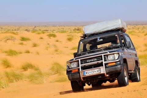 SUV with roof tent on the road in the desert