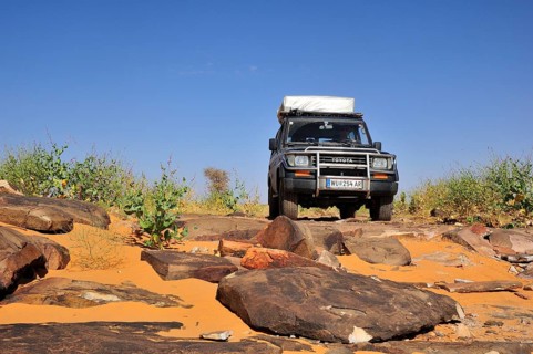 SUV with roof tent on rocky track