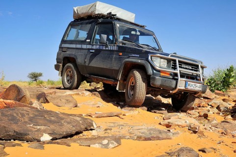 SUV with roof tent on rocky track