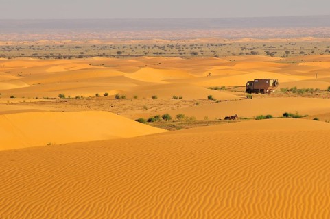 Truck with camping space passing through sand dunes
