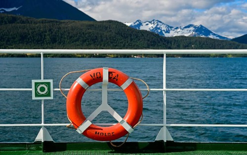 Lifebuoy on ferry Volda in front of a fjord landscape