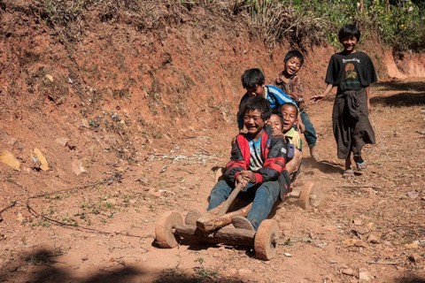Children from Palaung tribe ride homemade vehicle in Kalaw