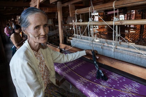 Old local woman weaving fabric from lotus flower silk