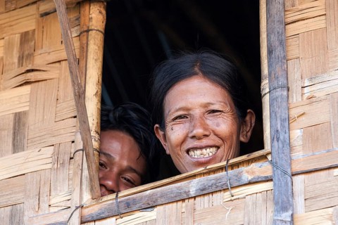 Native woman and boy looking out of a window