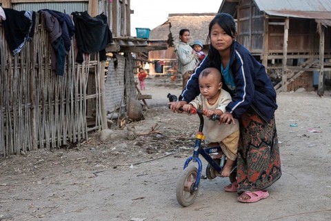Local girl with small child on a bicycle