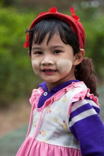 Local girl with a red cap and Thanaka paste on her face