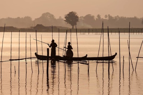 Two people standing in a dugout canoe