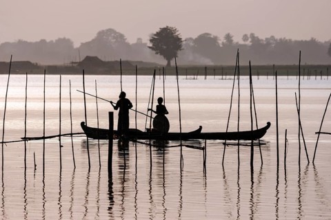 Two people standing in a dugout canoe