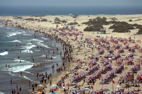 Crowded beach with umbrellas