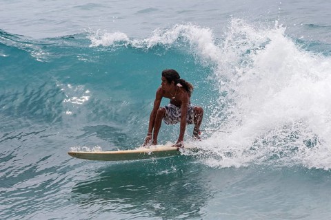 Local young man surfing the waves