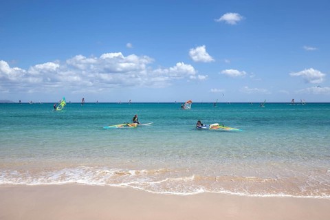 Windsurfers in the turquoise waters off the Playa Risco del Paso beach