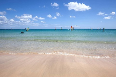 Windsurfers in the turquoise waters off the Playa Risco del Paso beach
