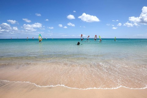 Windsurfers in the turquoise waters off the Playa Risco del Paso beach