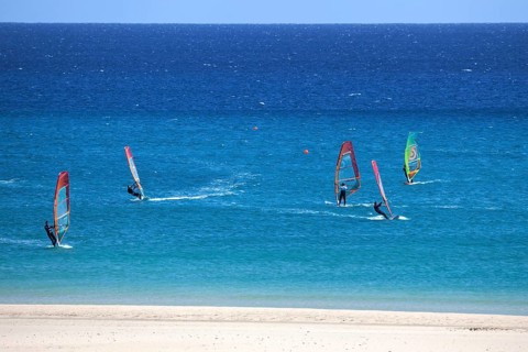Windsurfers in the turquoise waters off the Playa Risco del Paso beach
