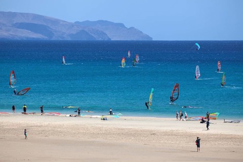 Windsurfers in the turquoise waters off the Playa Risco del Paso beach