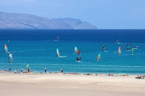 Windsurfers in the turquoise waters off the Playa Risco del Paso beach