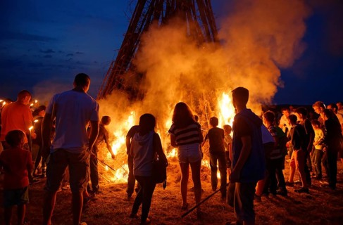 People standing around a Sonnwendfeuer bonfire