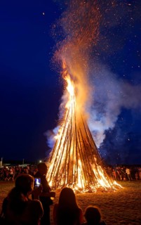 People standing around a Sonnwendfeuer bonfire