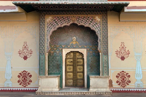 Brass gate with delicate wall paintings in the courtyard of the Chandra Mahal City Palace