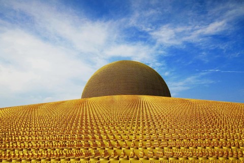 Buddhist temple Wat Phra Dhammakaya with golden Dhammakaya Buddha statues on the Chedi