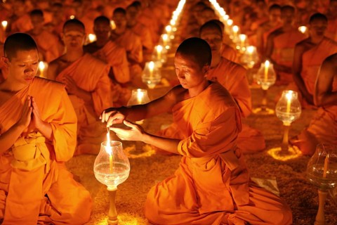 Monk lights candle