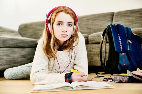 Girl with headphones doing homework