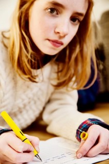 Girl doing her homework on the floor at home