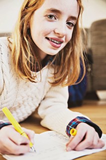 Girl doing her homework on the floor at home