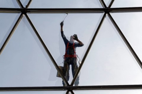 Painter painting the steel tube construction of a glass dome