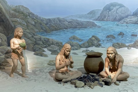 Indigenous people at a fire place on the coast