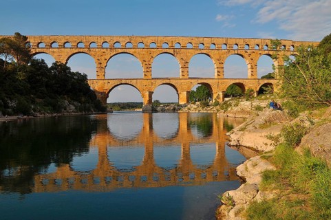 Roman aqueduct Pont du Gard reflected in the Gardon river