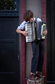 A busker plays an accordion