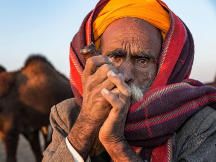 Elderly Rajasthani man with an turban smoking a hash pipe