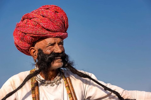 Portrait of an elderly Rajasthani man with a long beard wearing a turban