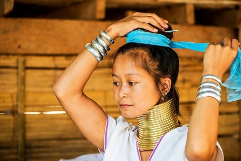 Young Kayan hill tribe woman does her hair in the morning