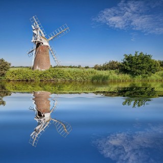 Turf Fen Windmill reflecting in the smooth waters of the Norfolk Broads