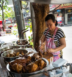 Street vendor preparing chicken at food stall