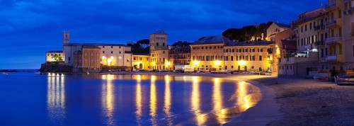 Town beach in the bay Baia del Silenzio with Chiesa di San Nicolo church