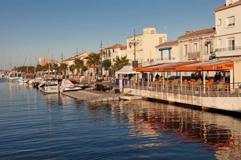 Promenade with restaurants and fishing boats at the harbor