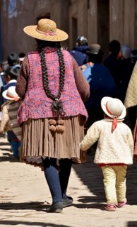 Child holding onto the coattails of its mother