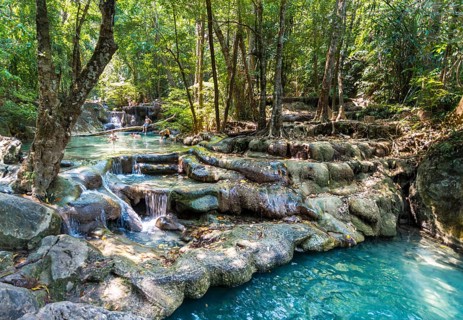 Tourists bathing in a waterfall in the Erawan National Park