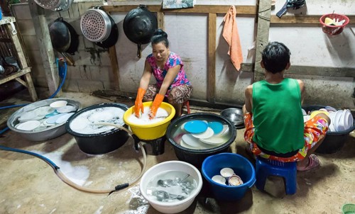 Thai woman washing dishes and pots