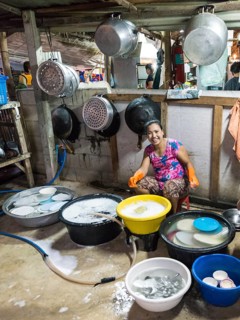 Thai woman washing dishes and pots